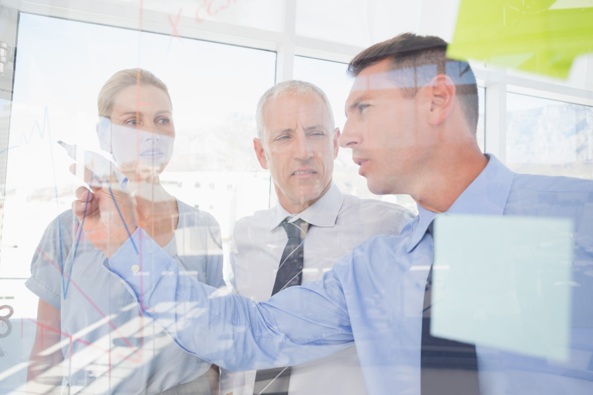 Drei Unternehmer brainstormen mit Post Its